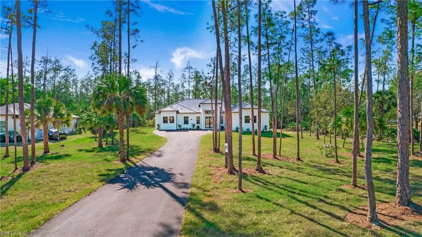 View of front facade featuring a front lawn and driveway