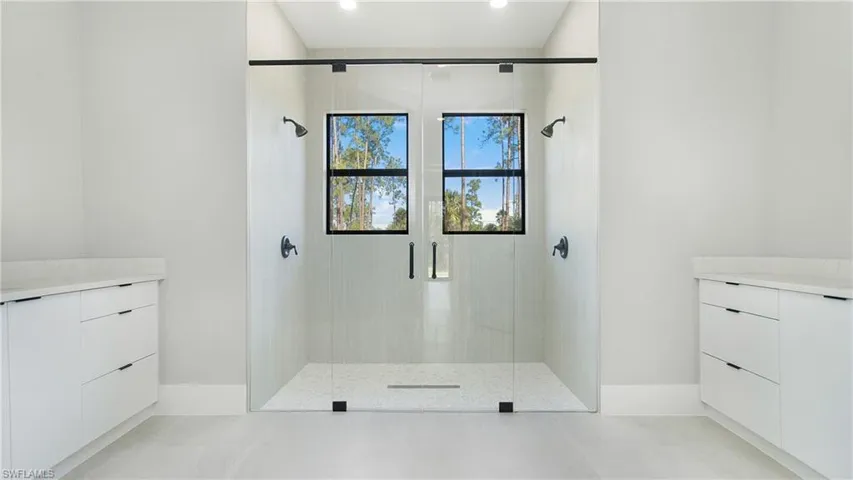 Bathroom with vanity, a stall shower, and light flooring