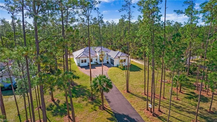 View of front facade featuring a front lawn, driveway, and stucco siding
