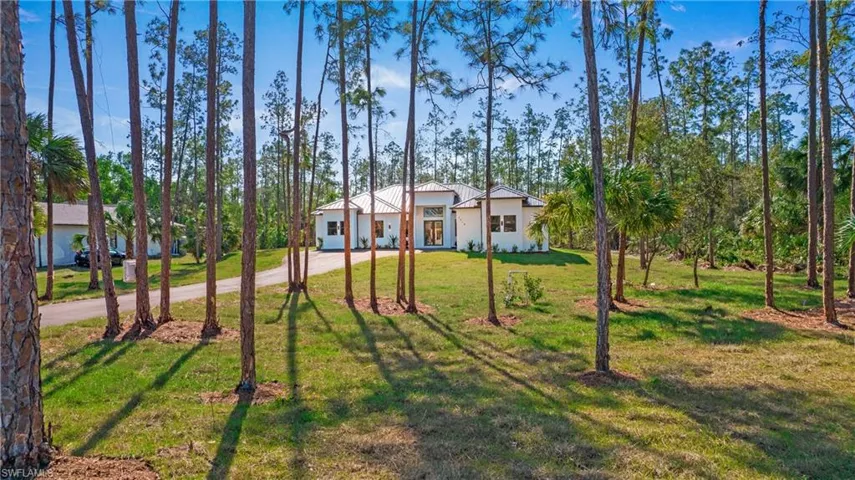 View of front facade featuring a front lawn, driveway, and stucco siding