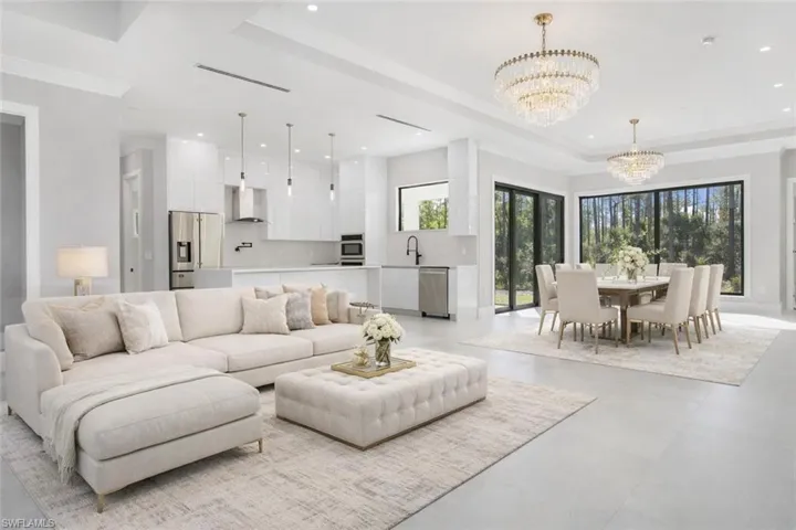 Virtually Staged Living room with suspended lighting, finished concrete flooring, and a tray ceiling