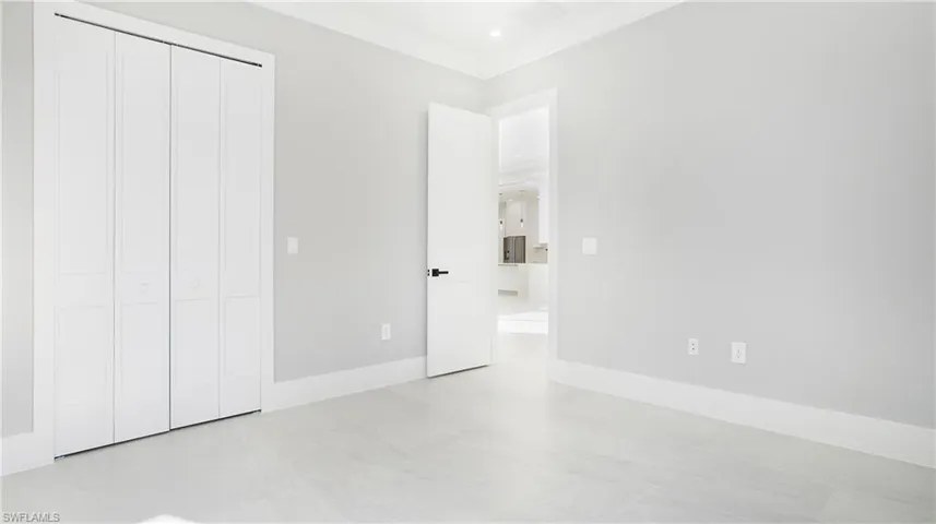 Unfurnished bedroom featuring recessed lighting, ornamental molding, and a closet