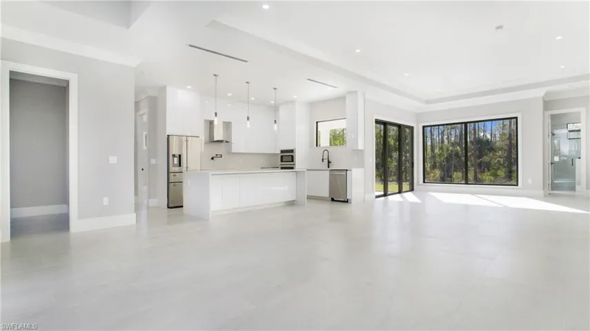 Unfurnished living room featuring a tray ceiling and recessed lighting
