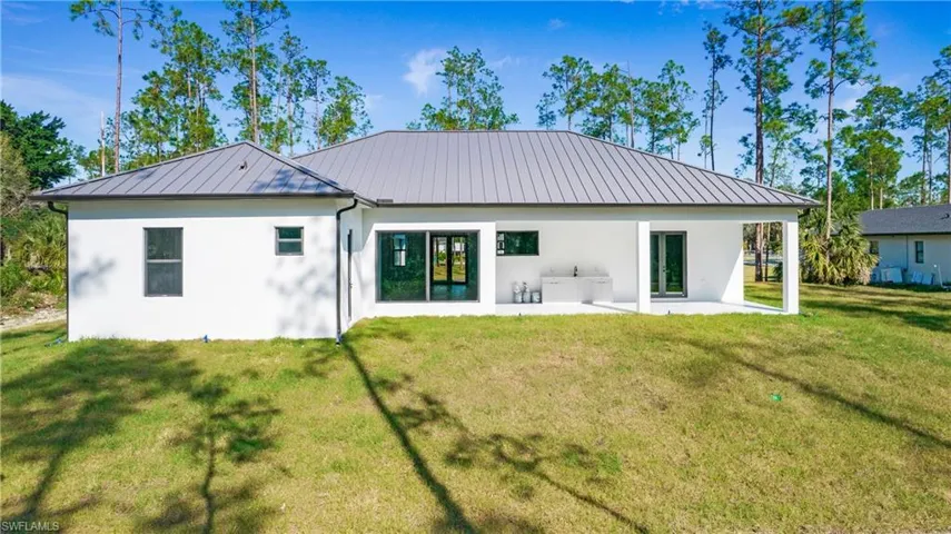 Back of property featuring stucco siding, a yard, and a patio