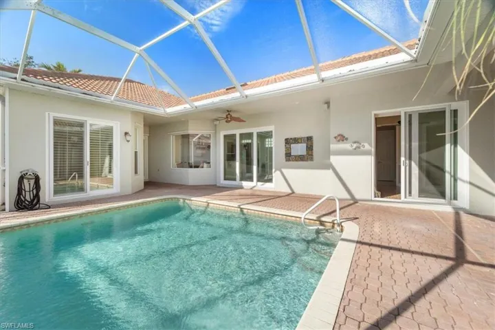View of swimming pool featuring a lanai, ceiling fan, and a patio