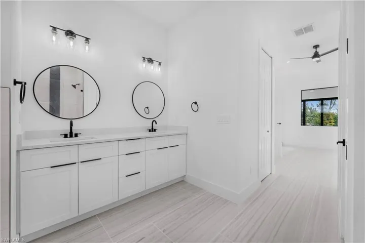 Full Maste bathroom featuring double vanity and a ceiling fan
