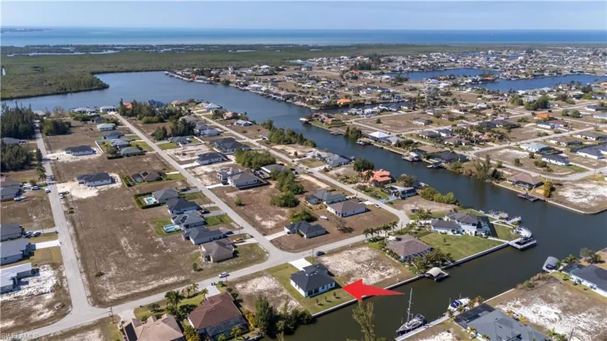 Aerial view of property and surrounding area with nearby suburban area and a nearby body of water