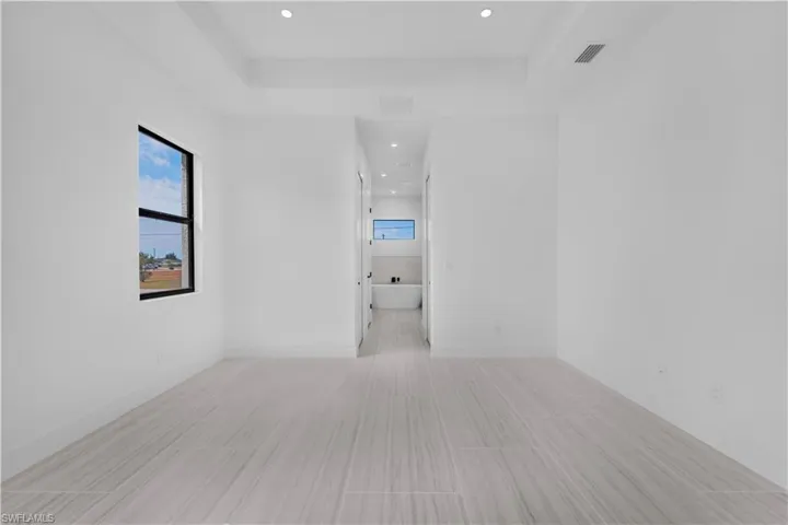 Master bedroom featuring recessed lighting and a tray ceiling