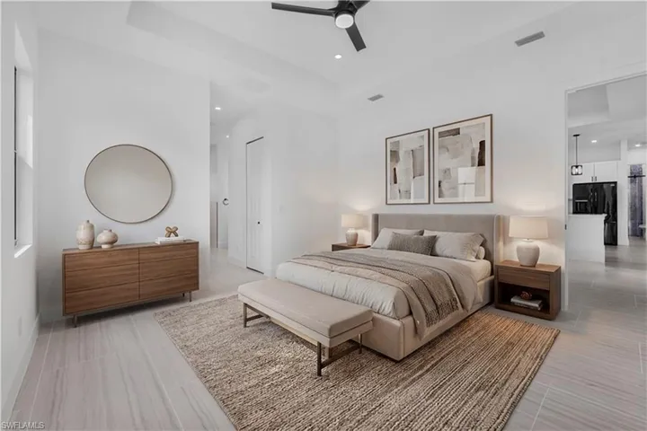 Bedroom featuring black fridge, ceiling fan, recessed lighting, and a raised ceiling