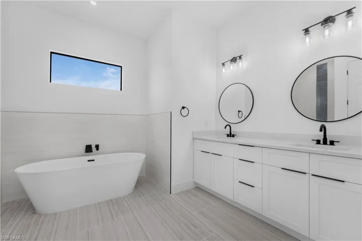 Master Bathroom with double vanity and a freestanding bath