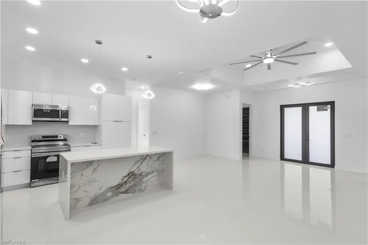 Kitchen featuring appliances with stainless steel finishes, modern cabinets, white cabinets, pendant lighting, and recessed lighting