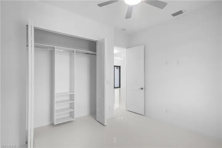Unfurnished bedroom featuring concrete floors, a ceiling fan, and a closet