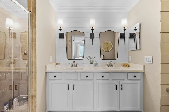 Bathroom with vanity, an enclosed shower, and ornamental molding