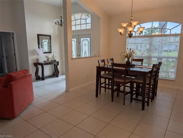Dining room featuring a chandelier, baseboards, and light tile patterned floors