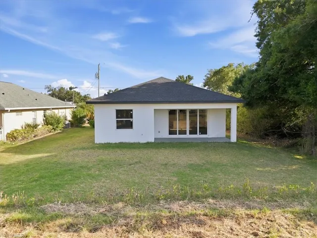 Contemporary white stucco exterior with a dark shingle roof