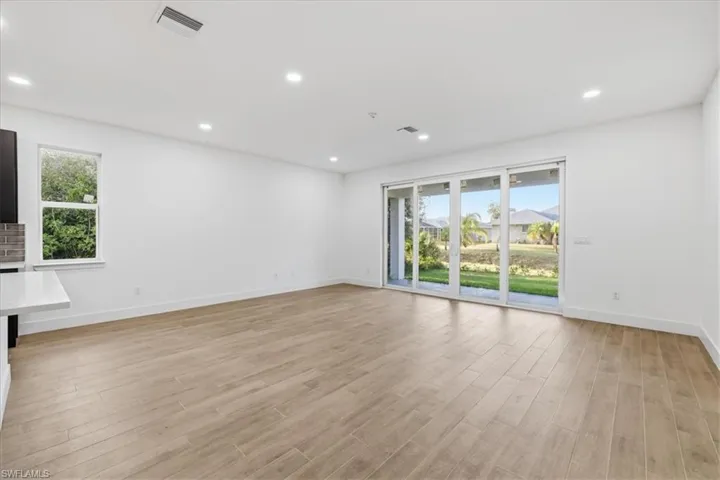 Spacious interior featuring wood-finish flooring, recessed lighting, and white walls