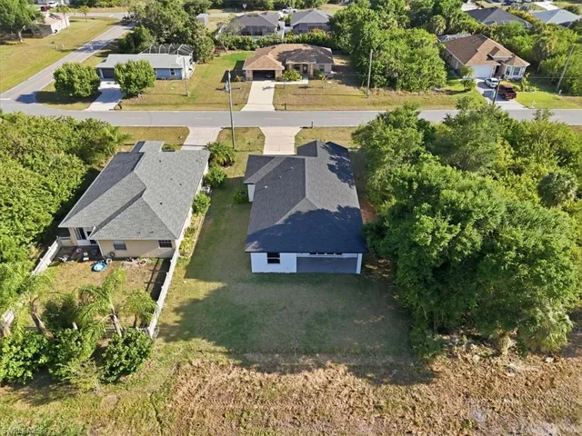 New construction residence featuring a dark shingle roof, light-toned exterior, and an attached two-car garage