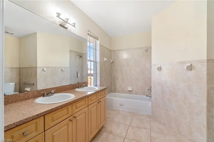 Spacious primary bathroom featuring dual sinks and separate tub and shower.