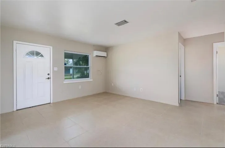 Foyer with a wall mounted air conditioner and baseboards