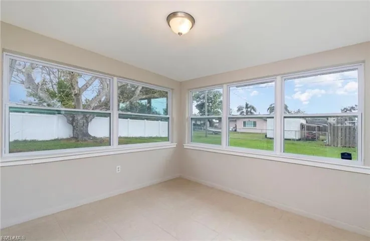 Unfurnished sunroom featuring baseboards