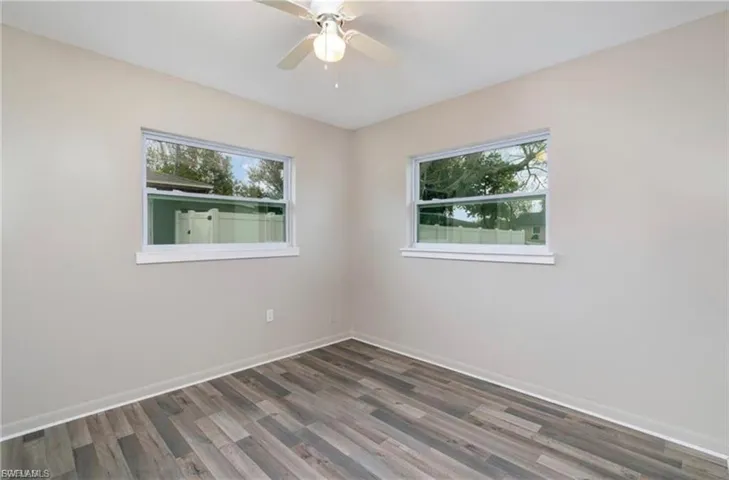 Spare room featuring plenty of natural light, wood finished floors, and a ceiling fan