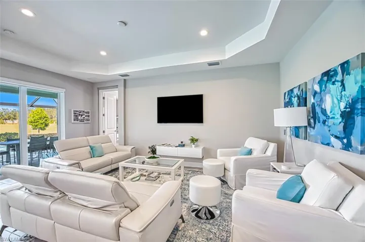 Living room featuring a tray ceiling and recessed lighting