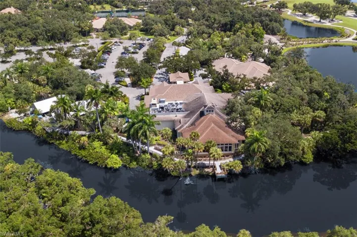 Aerial view of property's location featuring a large body of water and a tree filled landscape