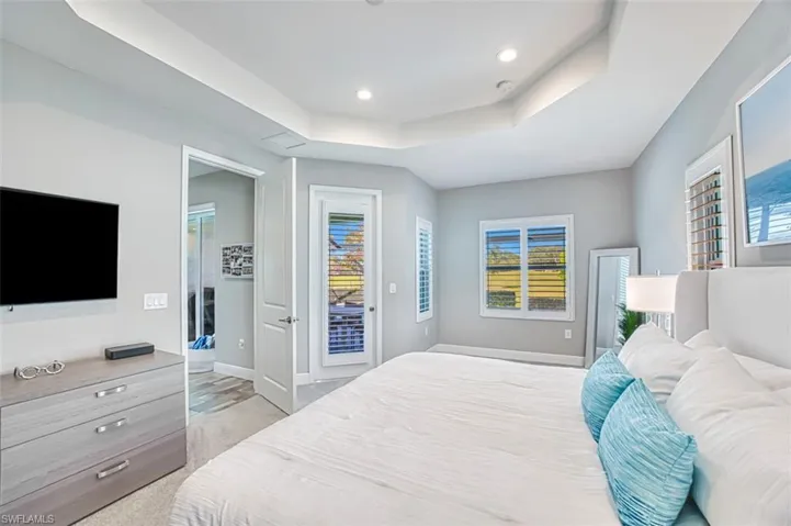 Bedroom featuring a tray ceiling, access to outside, recessed lighting, and light colored carpet