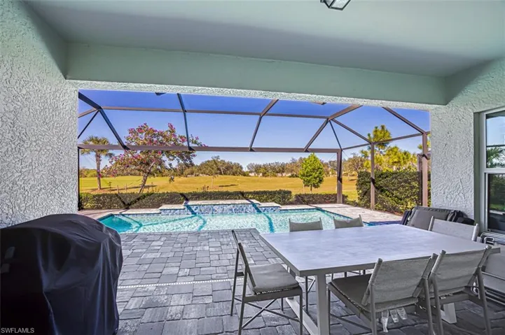 View of patio / terrace featuring a sunroom, a grill, an outdoor pool, and a lanai
