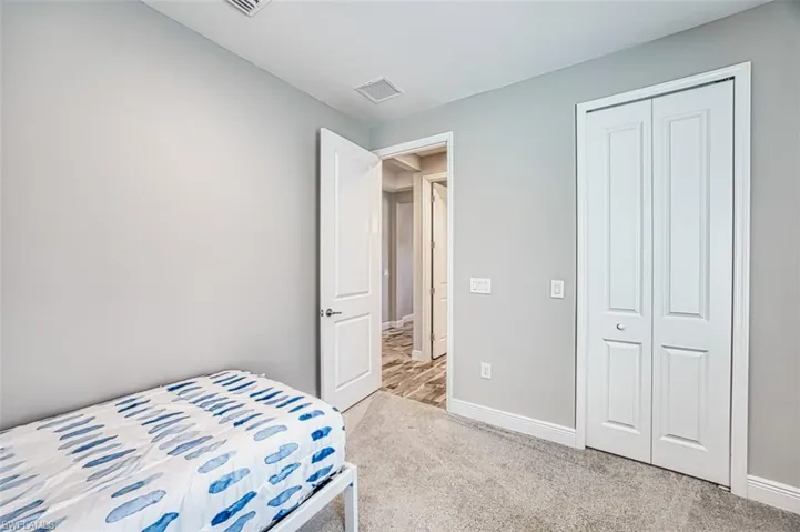 Bedroom with light carpet and a closet