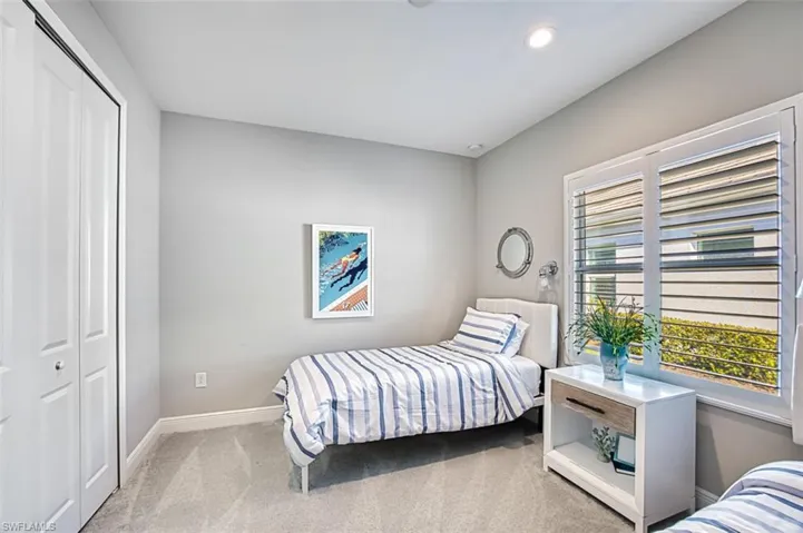 Bedroom with light colored carpet, a closet, and recessed lighting