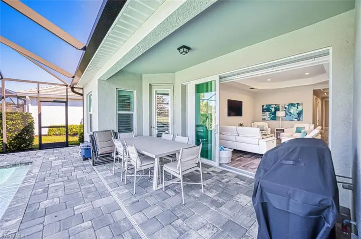 View of patio featuring a sunroom, outdoor lounge area, and glass enclosure