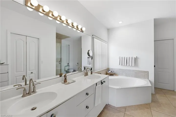 Primary bathroom features dual sinks, soaking tub and shower