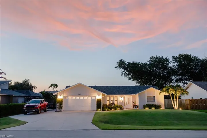 Single story home featuring a garage and a lawn