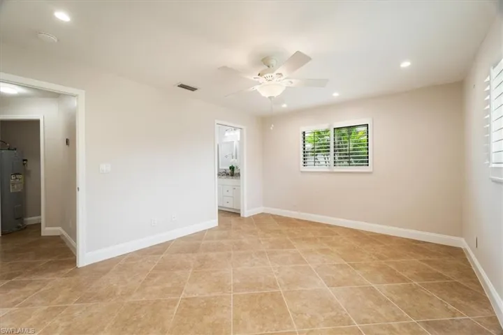 Tiled spare room with electric water heater and ceiling fan