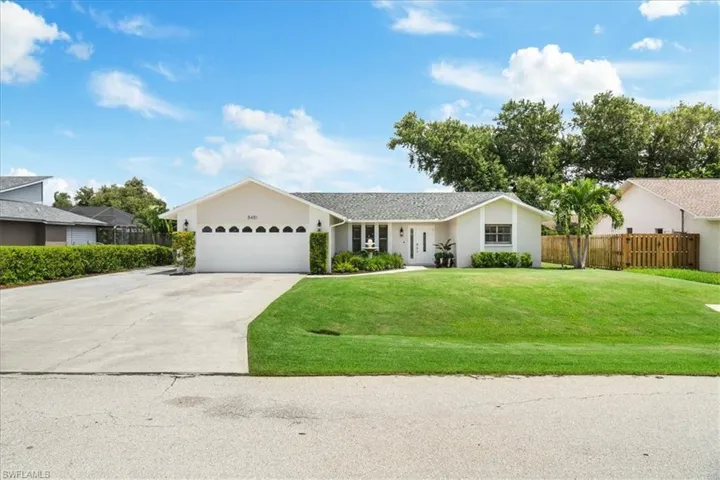 Ranch-style home featuring a front lawn and a garage
