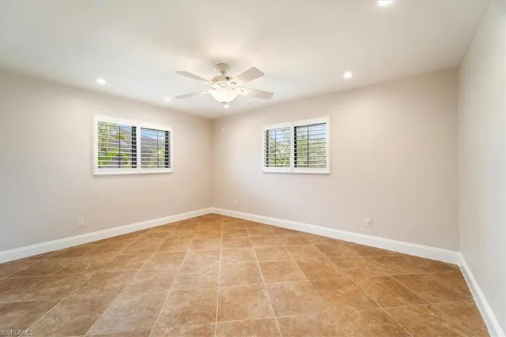Tiled empty room with ceiling fan and a wealth of natural light