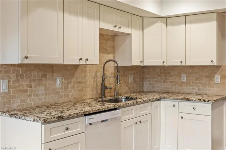 Kitchen featuring dishwasher, tasteful backsplash, and sink