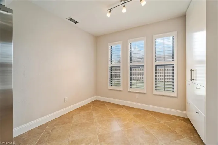 Spare room with light tile patterned flooring and rail lighting