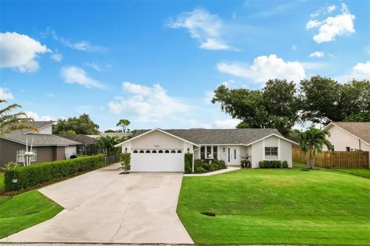 Single story home featuring a garage and a front yard