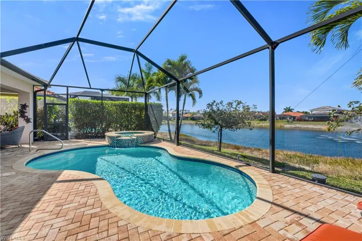 Relaxing pool / spa featuring a sunroom, a water view, a lanai, and a patio area