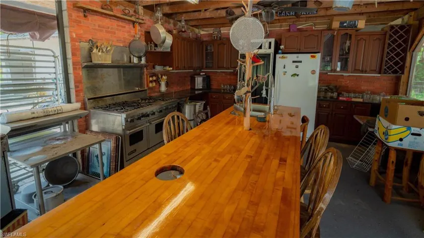 Kitchen featuring double oven range, sink, a wealth of natural light, and brick wall