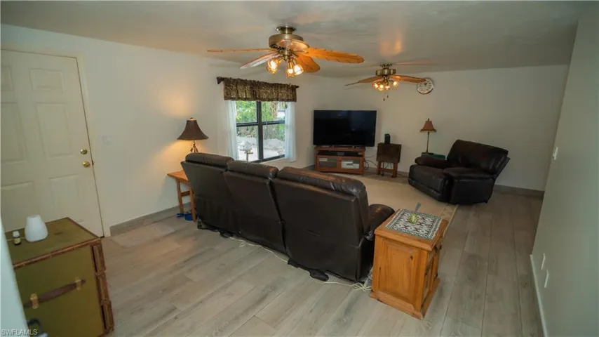 Living room featuring ceiling fan and light hardwood / wood-style flooring