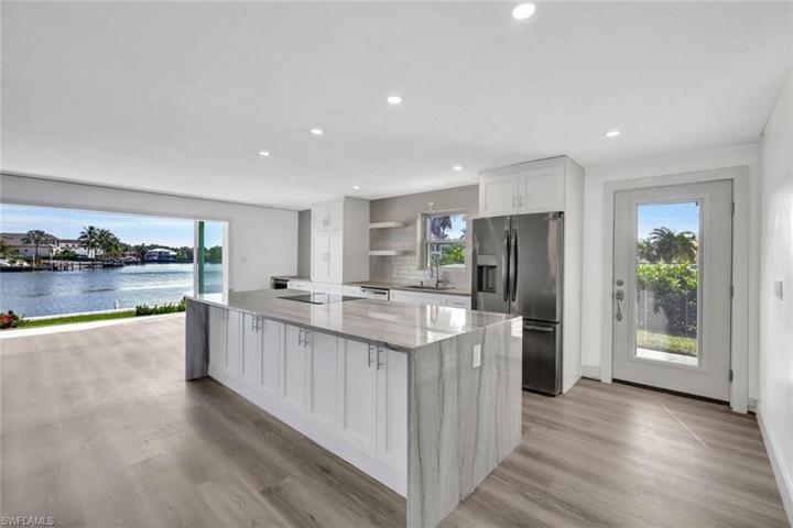 Chefs kitchen overlooks living and dining areas.  Kitchen features custom soft close cabinets, Waterfall counters on the island, cook top range and separate convection/ microwave oven, wine fridge, large picture windows, floor to ceiling bay-front sliders and softly lit with abundant canister lighting.