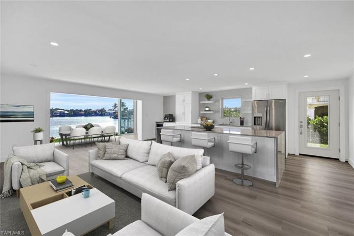 Chefs kitchen overlooks living and dining areas.  Kitchen features custom soft close cabinets, Waterfall counters on the island, cook top range and separate convection/ microwave oven, wine fridge, large picture windows, floor to ceiling bay-front sliders and softly lit with abundant canister lighting.