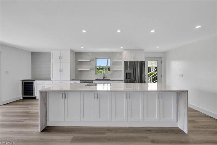Chefs kitchen overlooks living and dining areas.  Kitchen features custom soft close cabinets, Waterfall counters on the island, cook top range and separate convection/ microwave oven, wine fridge, large picture windows, floor to ceiling bay-front sliders and softly lit with abundant canister lighting.