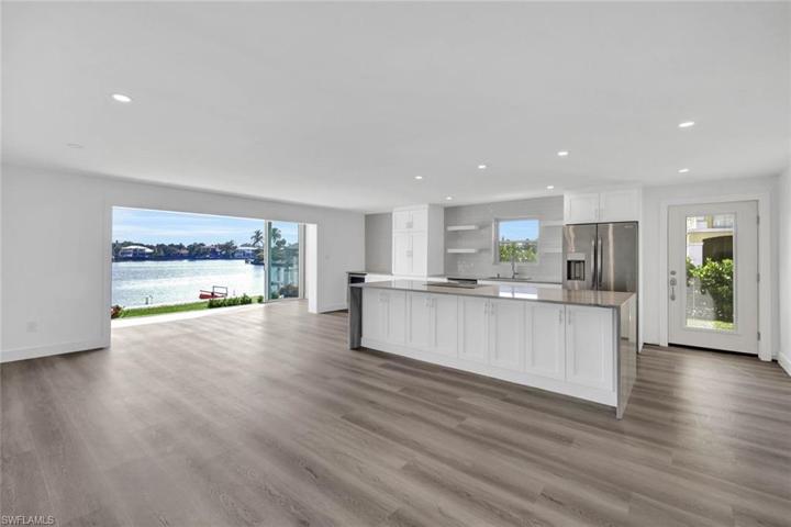 Chefs kitchen overlooks living and dining areas.  Kitchen features custom soft close cabinets, Waterfall counters on the island, cook top range and separate convection/ microwave oven, wine fridge, large picture windows, floor to ceiling bay-front sliders and softly lit with abundant canister lighting.