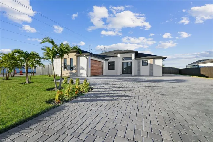 View of front of home with a garage and a front lawn