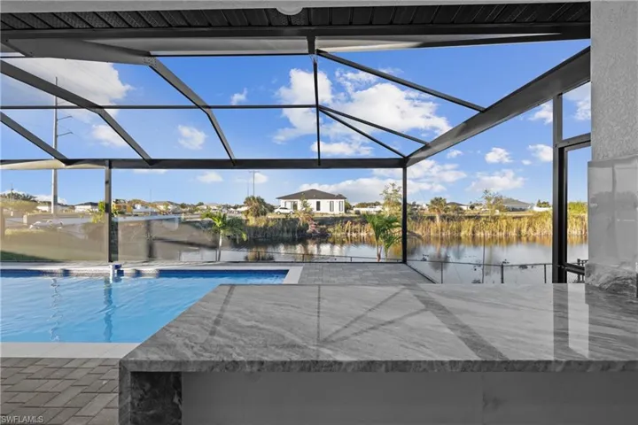 View of pool with a lanai, a patio area, and a water view