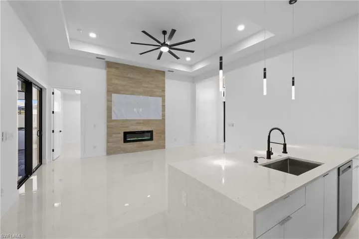 Kitchen featuring pendant lighting, white cabinetry, and a raised ceiling